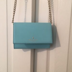 A light blue small crossbody kate spade purse